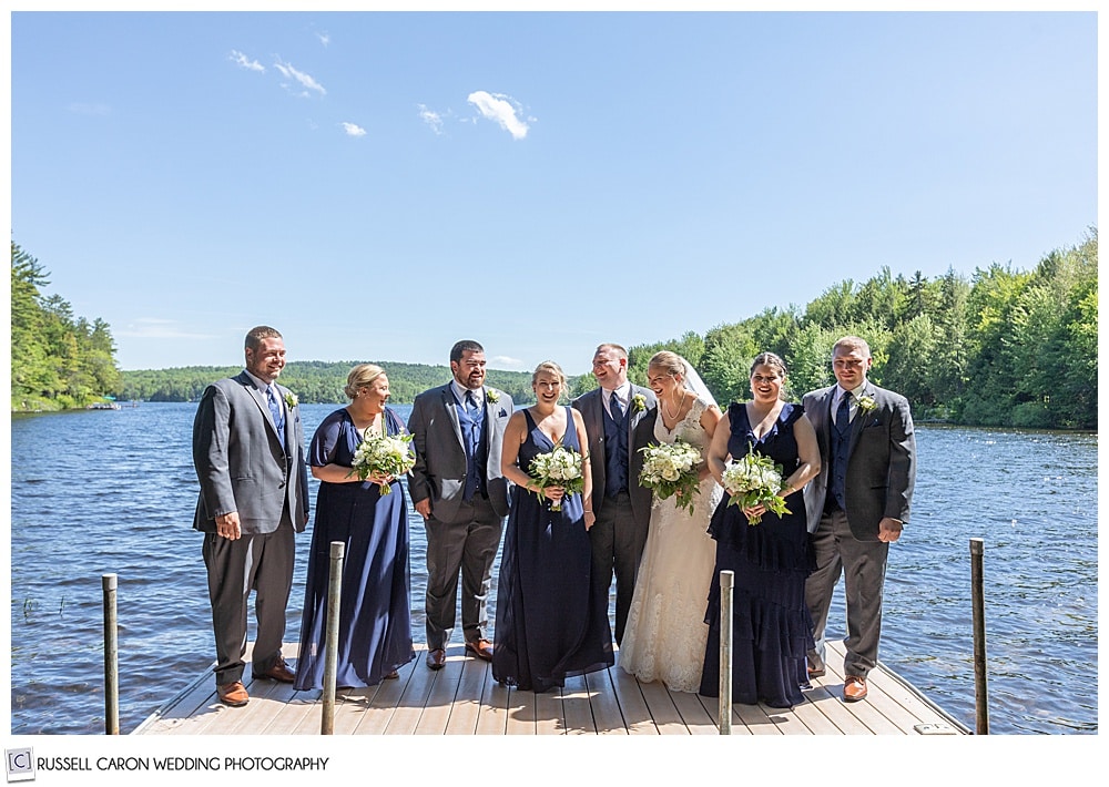 bridal party at the end of a dock on a lake in maine