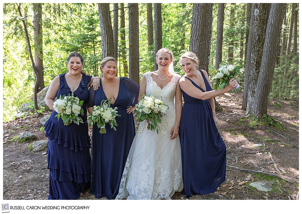 bride and bridesmaids laughing in the woods