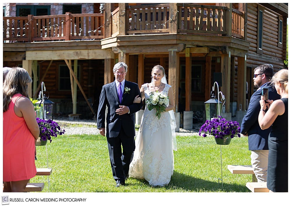 bride and her father walking towards the ceremony site in a back yard wedding