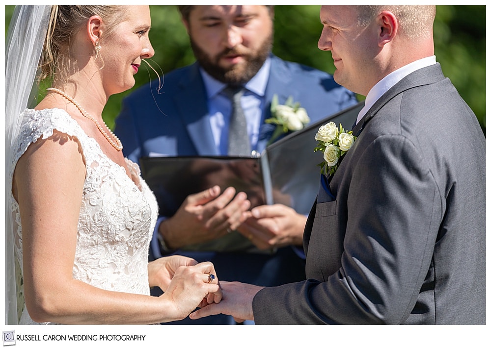 bride putting ring on the groom