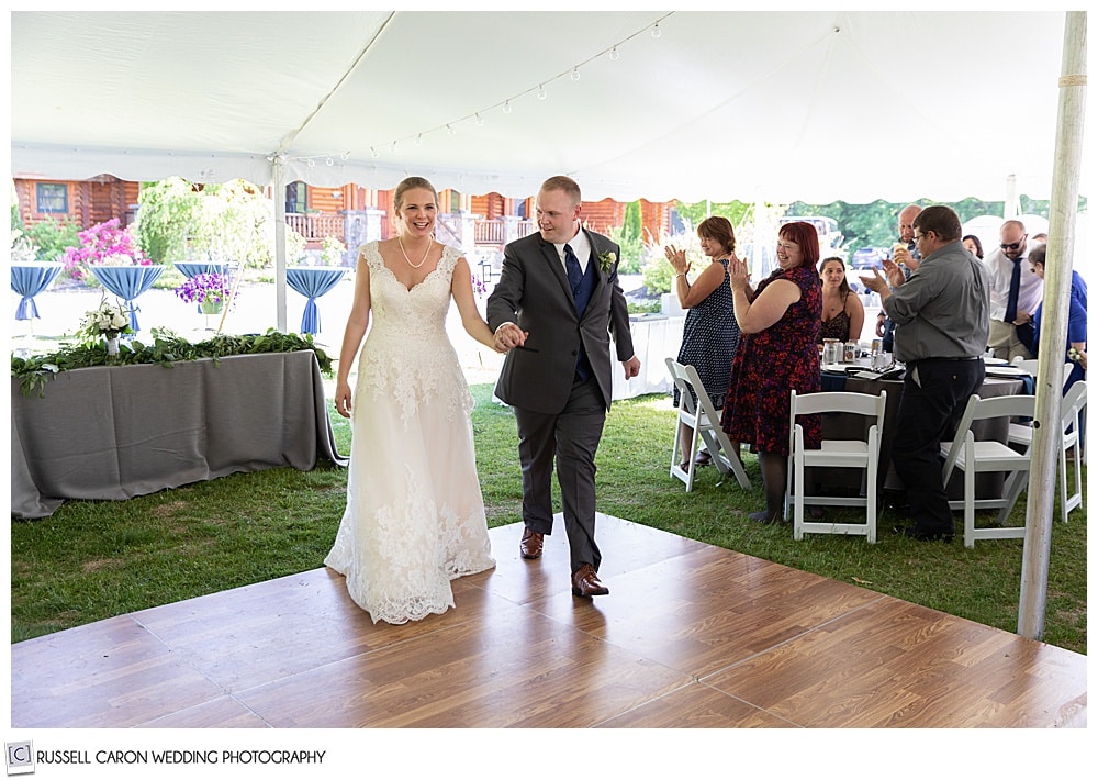 bride and groom walking onto a dance floor