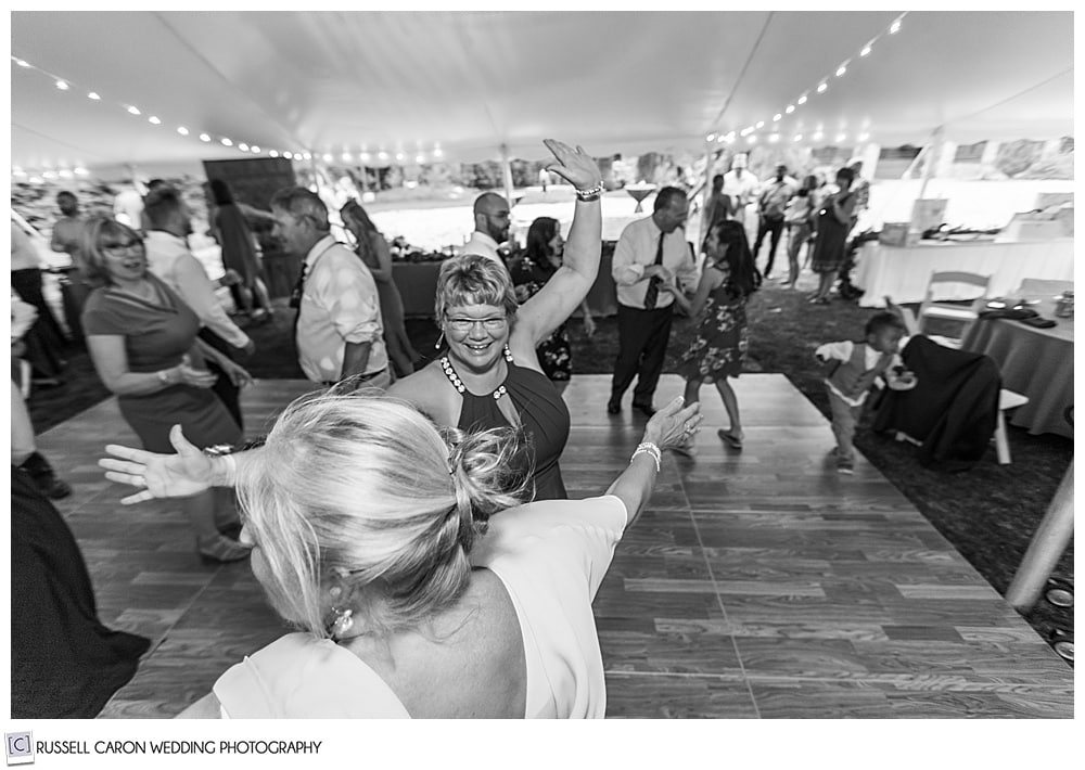 black and white photo of people dancing under an event tent