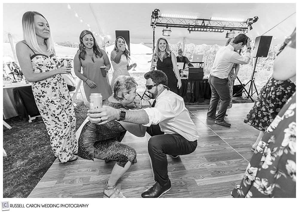 black and white photo of two people dancing, crouched down toward the dance floor