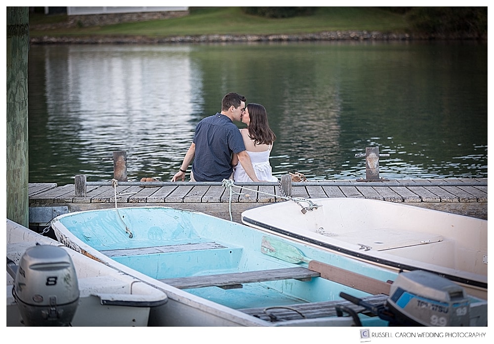 mand and woman kissing on a dock