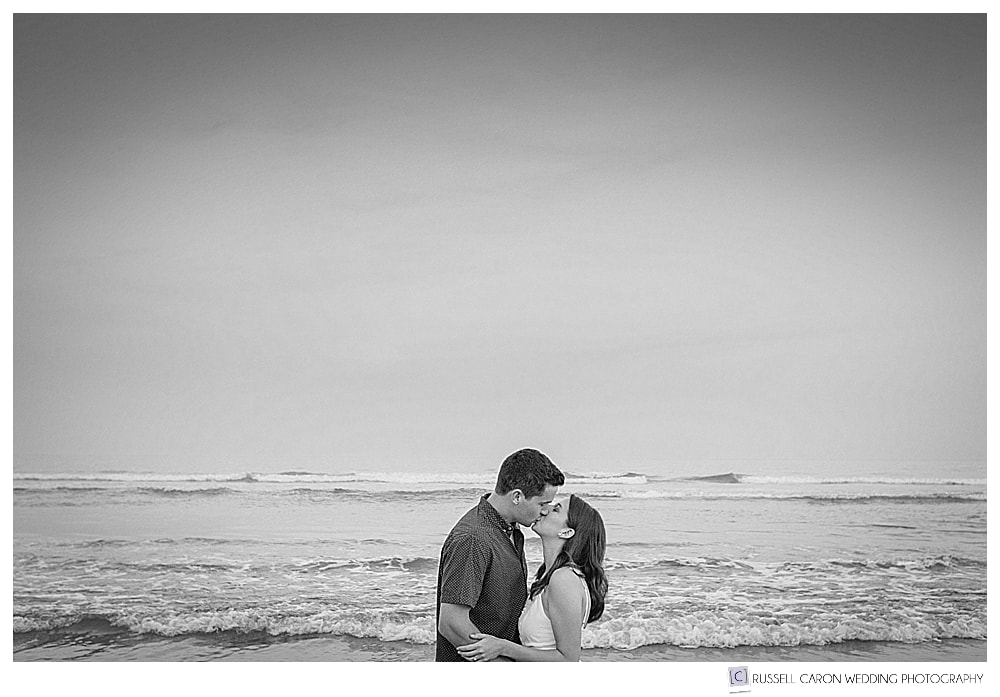black and white photo of man and woman kissing at the beach in York Beach Maine