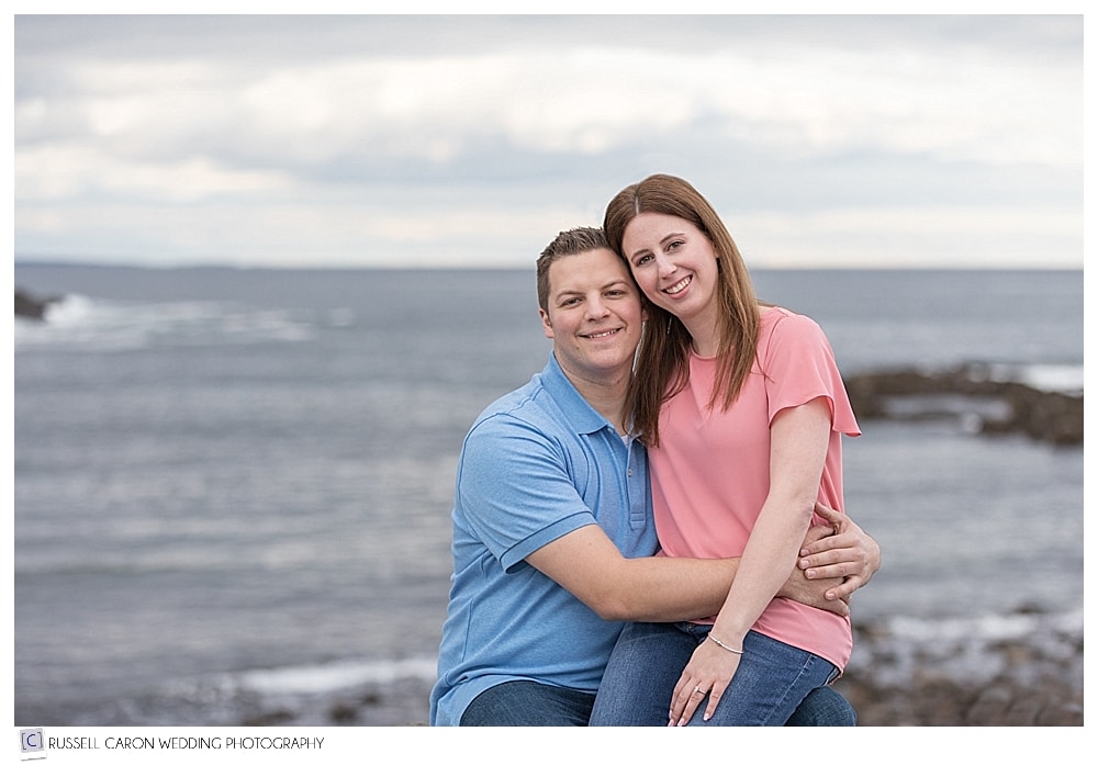Couple sitting together and smiling during Ogunquit Maine engagement photos