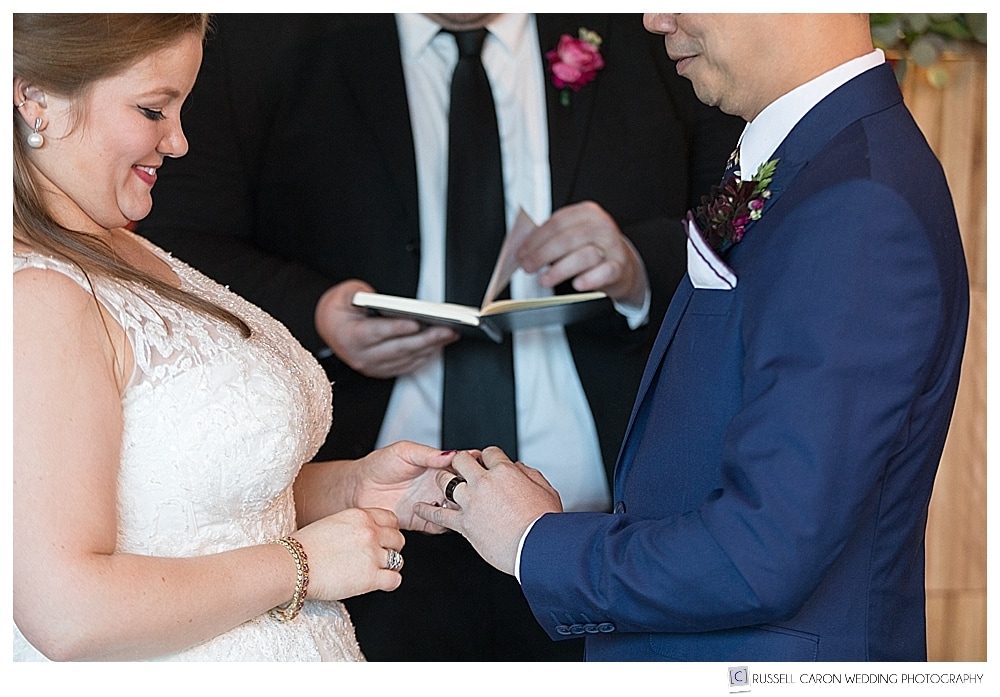bride puts ring on groom's finger
