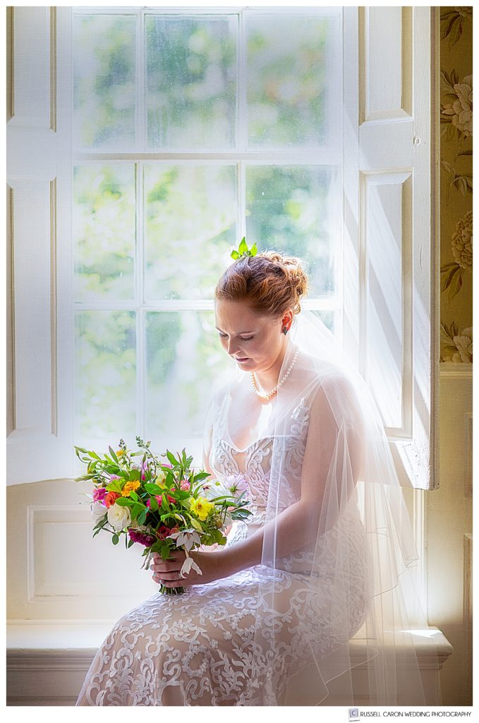 a serene bridal portrait of a bride sitting by a window