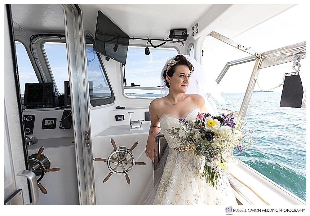 A unique bridal portrait of a bride on a lobster boat in Maine