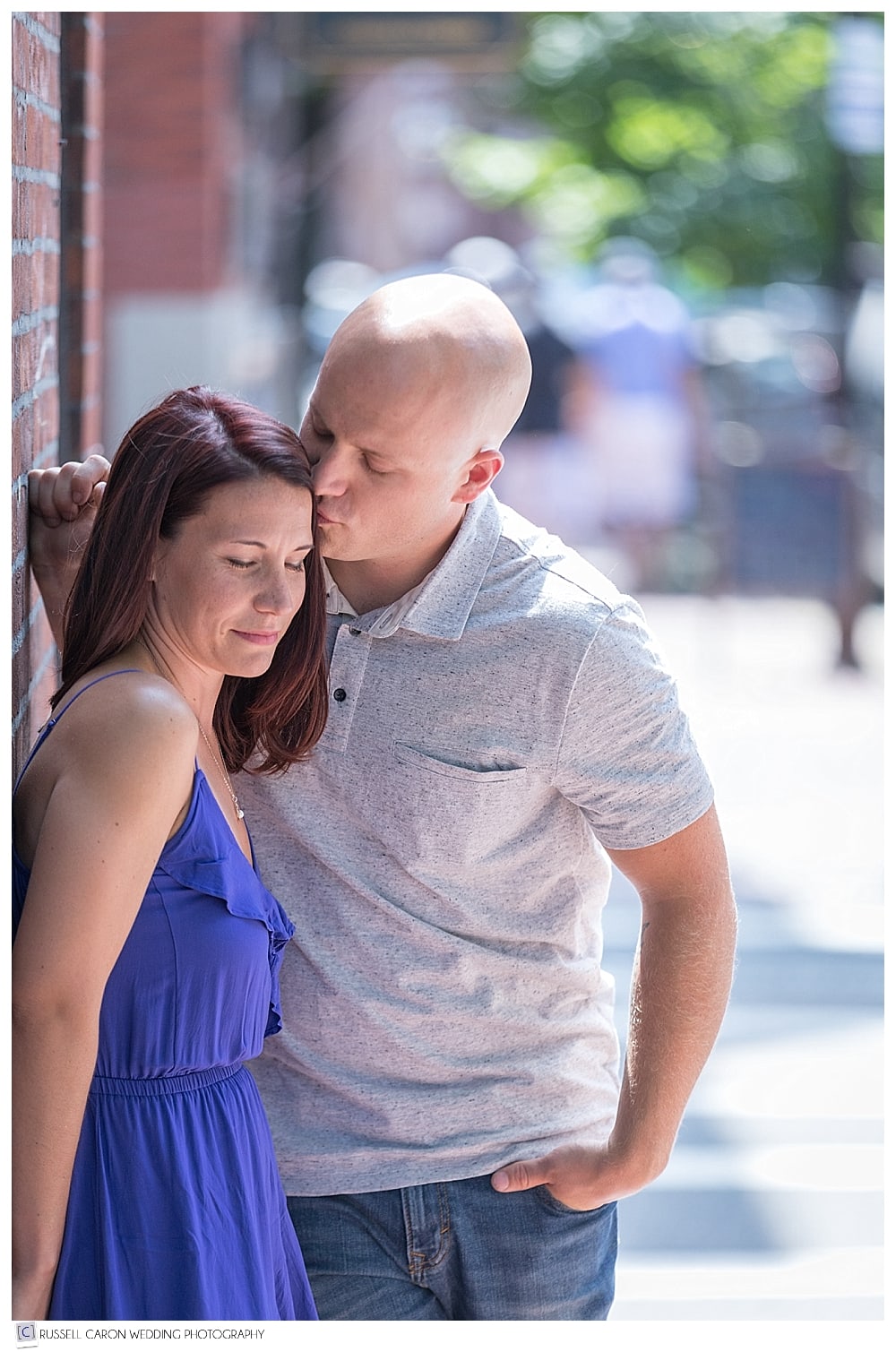 man kissing woman on the temple during Acorn Street Boston engagement session