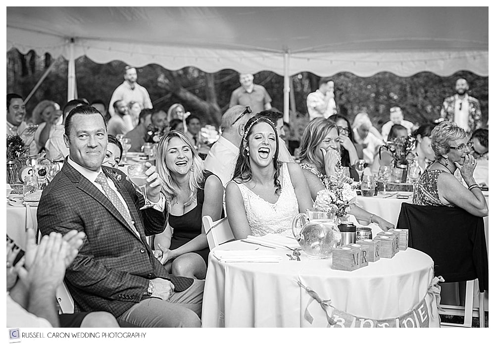 bride and groom laughing during wedding reception toasts