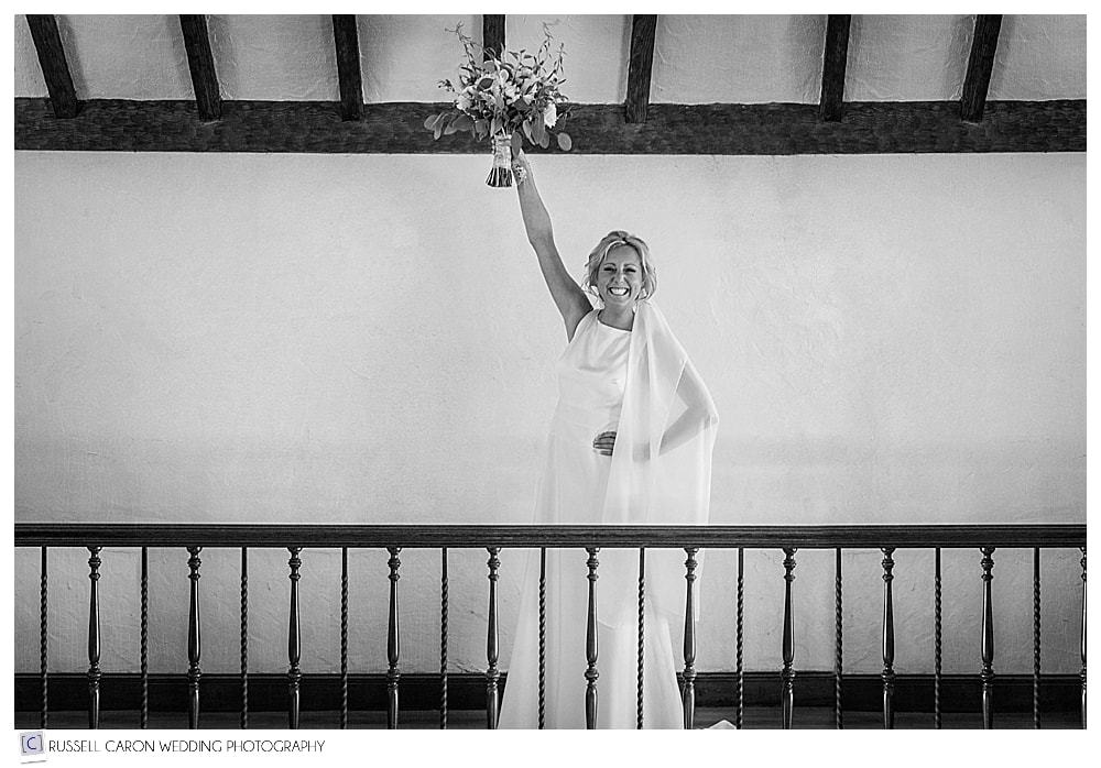 bride holds bridal bouquet up in the air