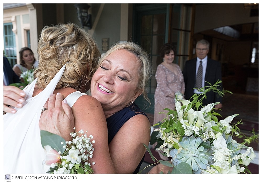 Bride and her mother hugging after wedding ceremony