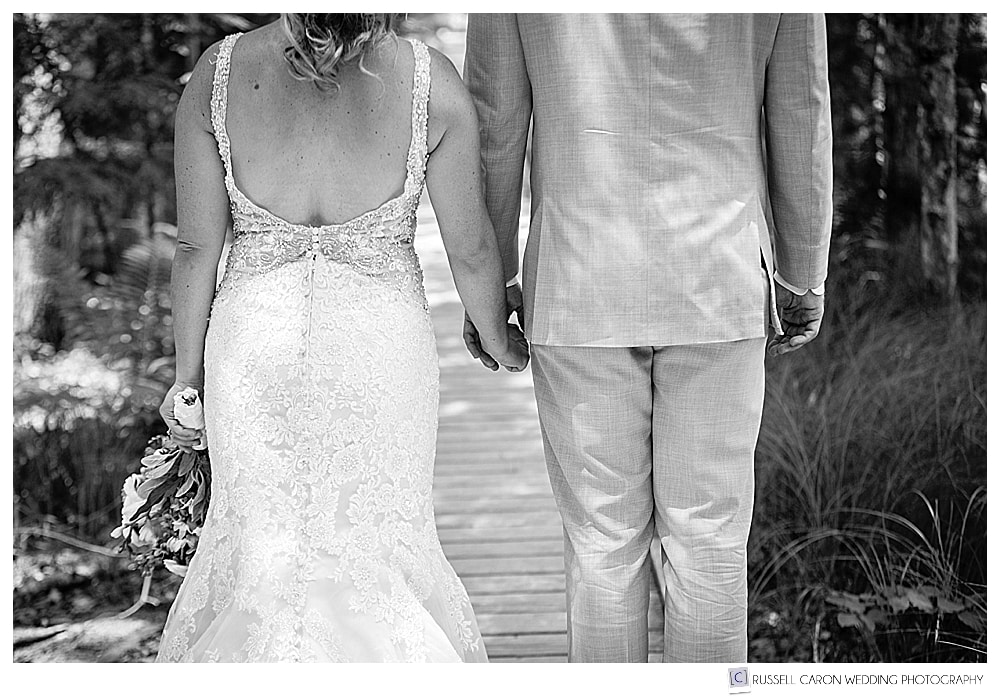 bride and groom holding hands, walking on a walkway in Acadia National Park, Bar Harbor, Maine. Maine weddings photographer