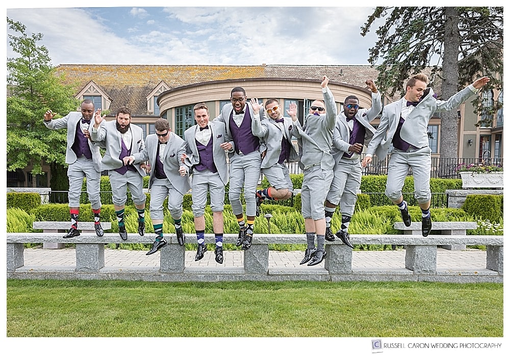 groom and groomsmen jumping off a bench, at the Bar Harbor Club. Bar Harbor Maine weddings.