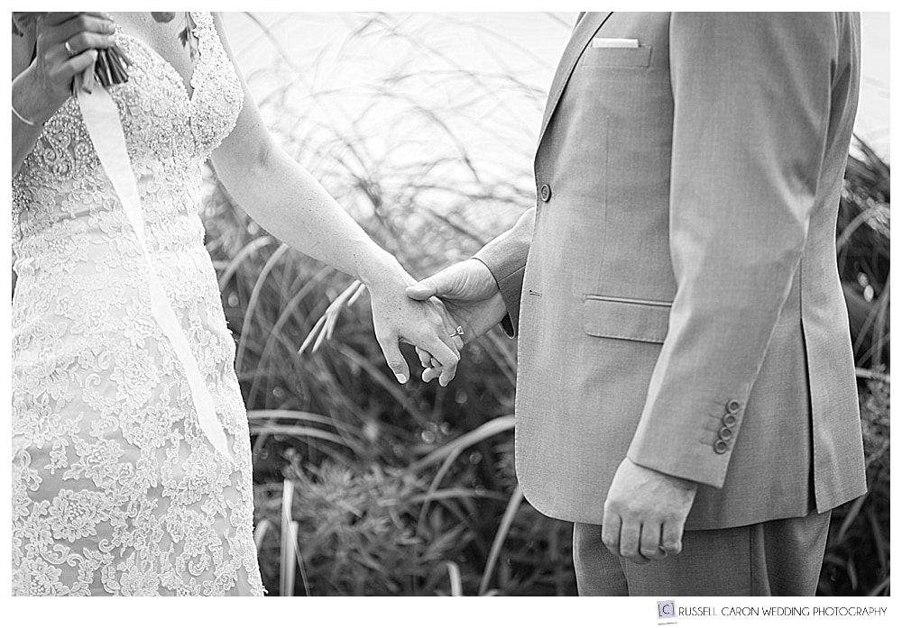 black and white photo of groom holding brides hand