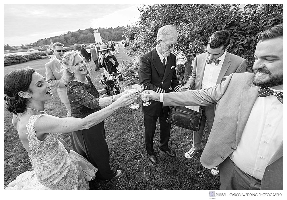 black and white photo of bride and groom toasting with champagne 