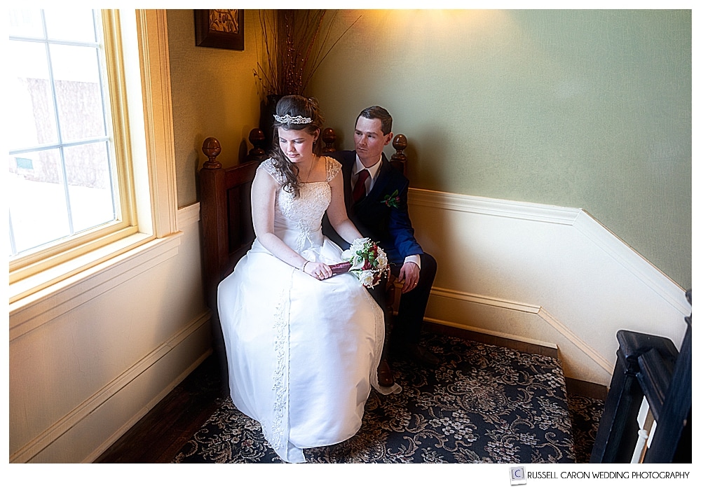 bride and groom sitting together near a window