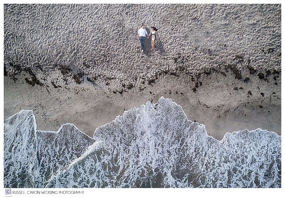 Man and woman lying on the beach, photo by Maine drone wedding photographers