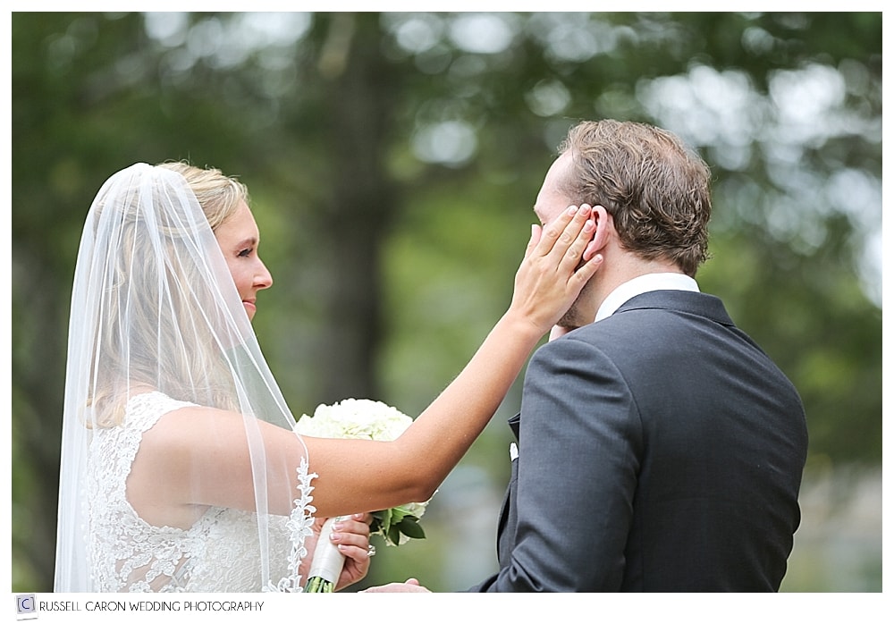 bride wipes tear from groom after first look