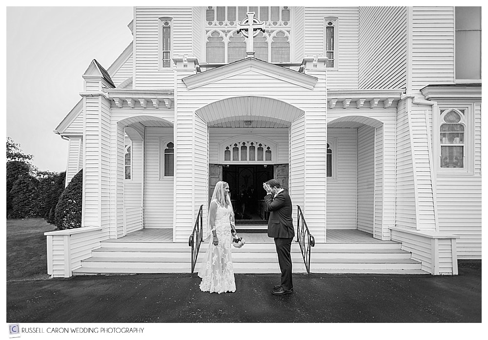 bride and groom standing in front of Our Lady Queen of Peace Church Boothbay Harbor Maine