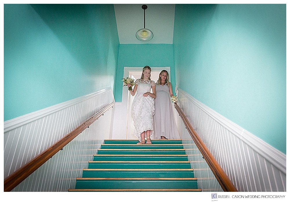 bride and matron of honor coming down the stairs in a turquoise stairwell