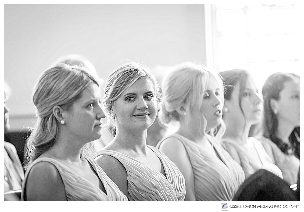 black and white photo of bridesmaids in a church pew