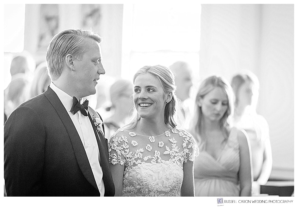 black and white photo of bride looking at groom during wedding ceremony