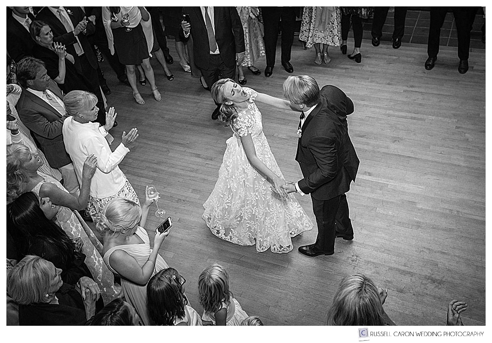 black and white photo of bride and groom having fun during their first dance