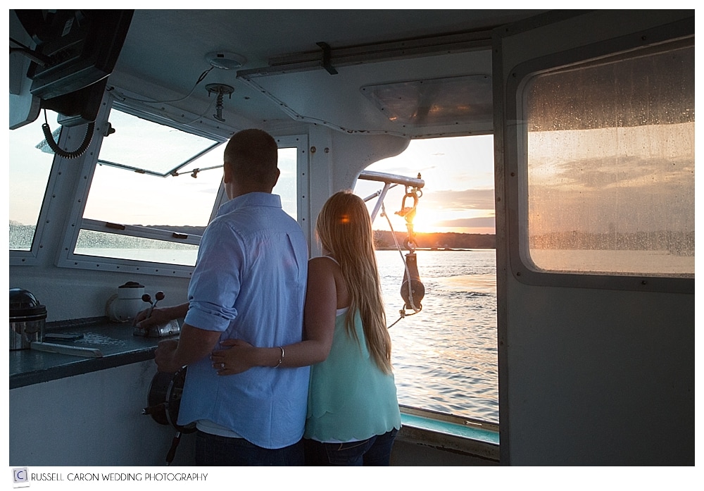 couple-driving-lobster-boat-during-sunset