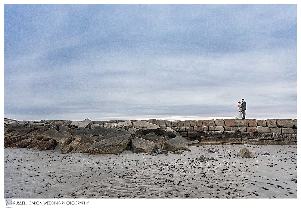 bride and groom on the breakwater in Kennebunkport Maine