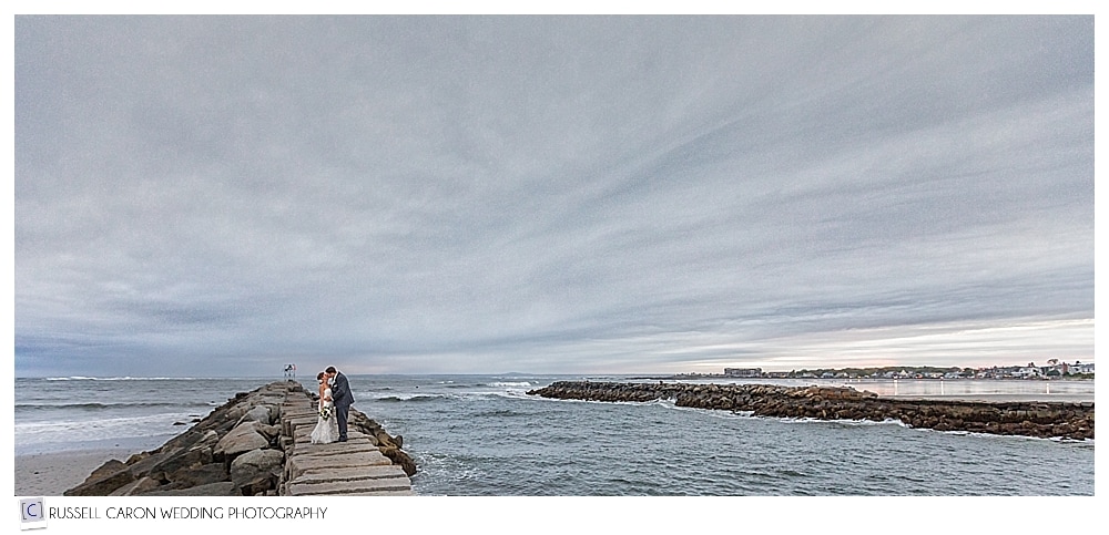 bride and groom kissing on the Kennebunkport Maine breakwater