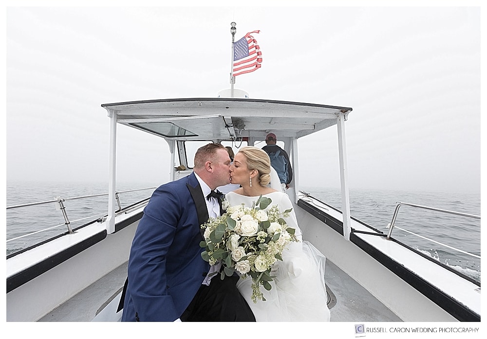bride and groom kissing on a lobster boat
