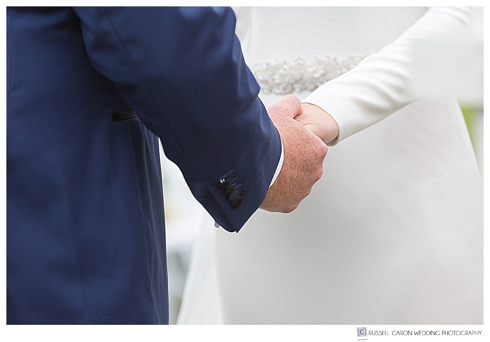 bride and groom holding hands during wedding ceremony