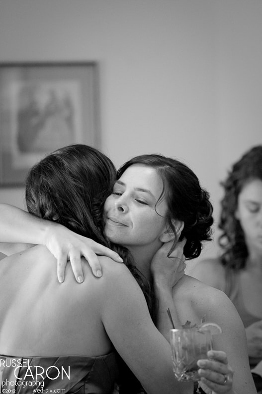 The bride receives a hug from a bridesmaid
