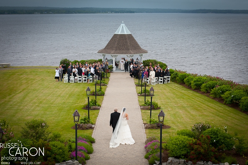 Bride and father of the bride approaching the gazebo during the wedding ceremony processional