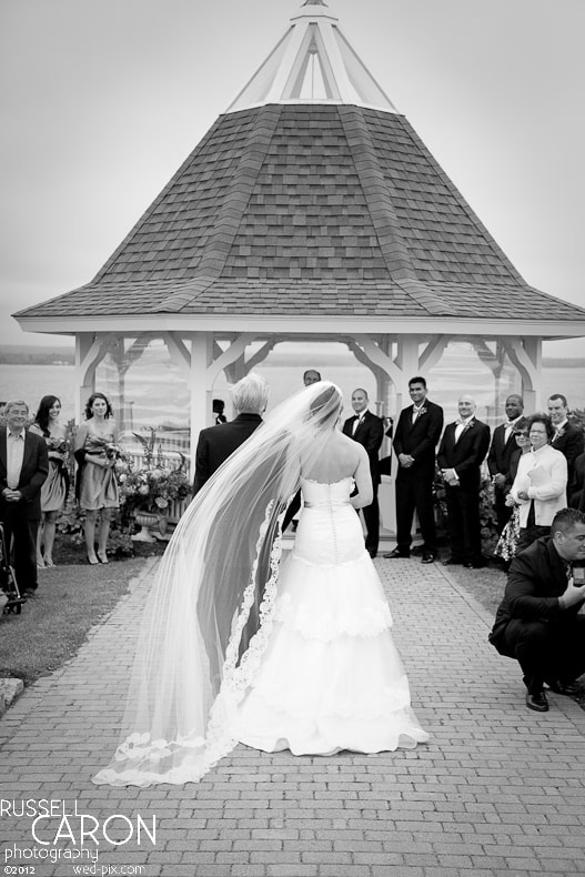 Bride's veil blows in the wind at a Maine wedding