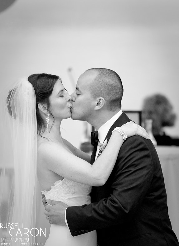 Bride and groom during wedding ceremony first kiss