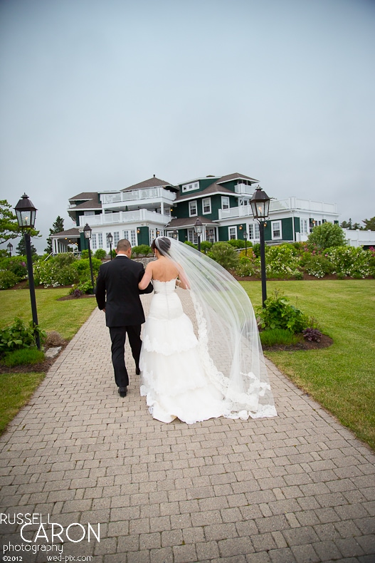 Bride and groom with veil blowing in the wind