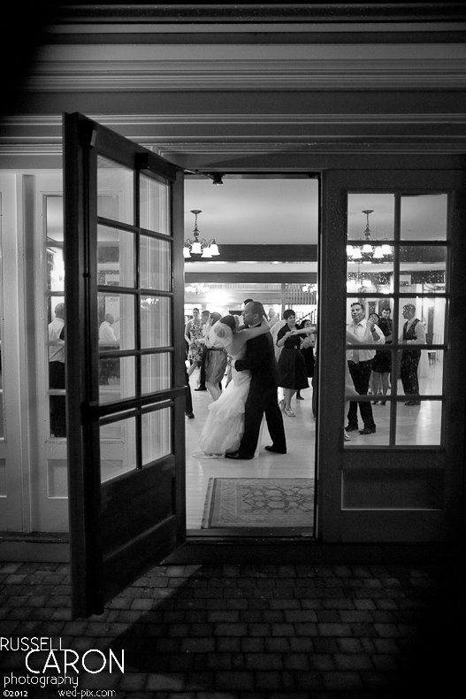 Outside looking inside at bride and groom dancing