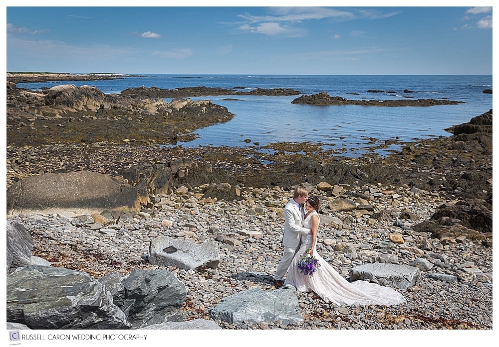 bride and groom on the rocks by the ocean