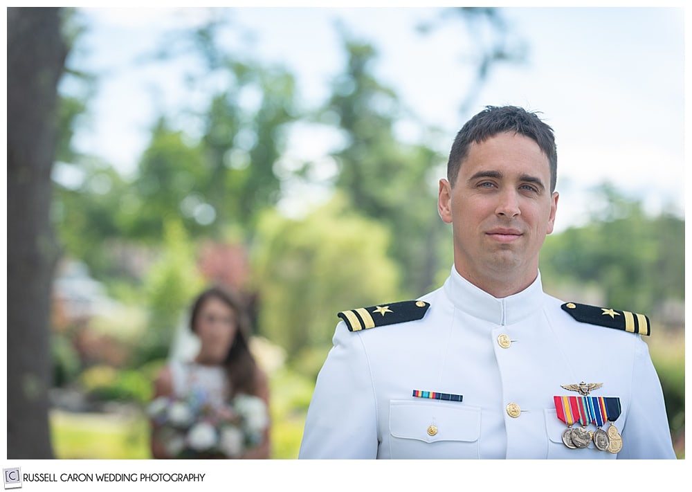 groom facing camera, his back to his bride behind him, just before their wedding day first look