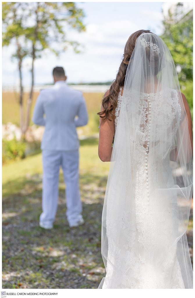 bride, with her back to the camera, and groom with his back to the bride, just before their wedding day first look