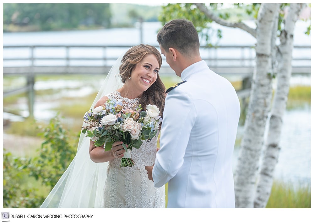 bride smiling at groom during first look photos