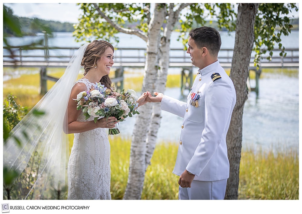 bride and groom holding hands and looking at each other during their first look photos