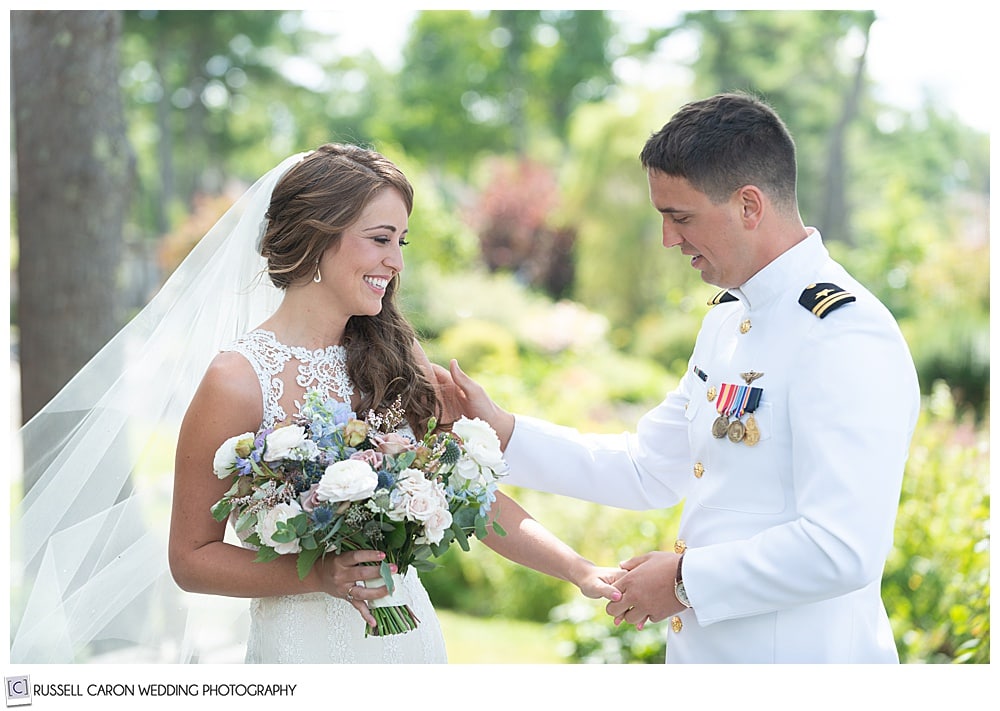 groom holding brides hand, looking at her during their first look photos