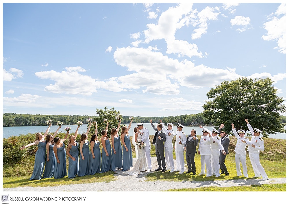 bridal party photo at Fort Edgecomb, Edgecomb, Maine. Bride and groom are kissing while the bridal party cheers