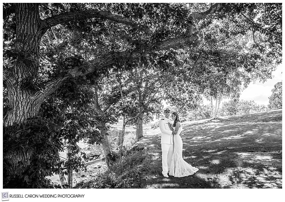 black and white photo of a bride and groom standing together looking at the camera