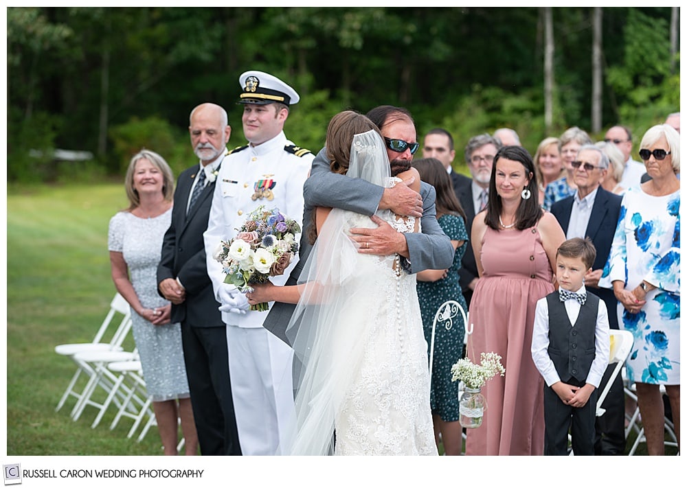 bride hugs her father after they walk down the aisle