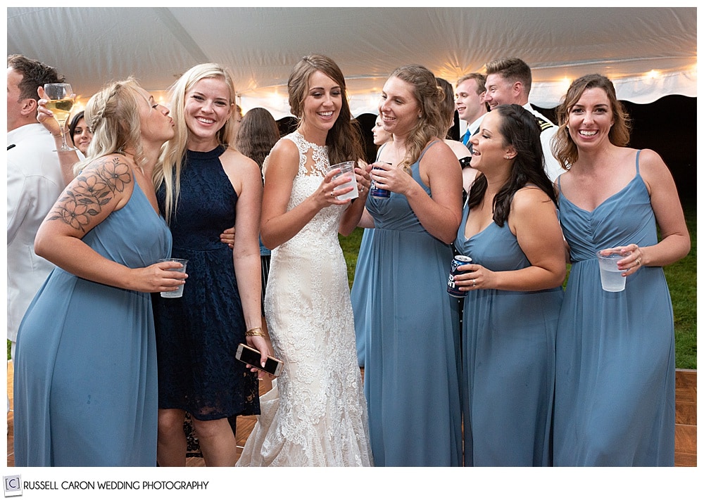 bride standing with bridesmaids and friends during her wedding reception